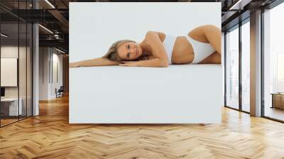 Beautiful woman with perfect body lying isolated on white background Wall mural